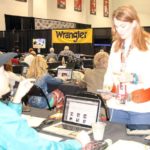 Aaron Kuhl and Gretchen Kirchamann texting at the at the 2014 Wrangler NFR Press Room