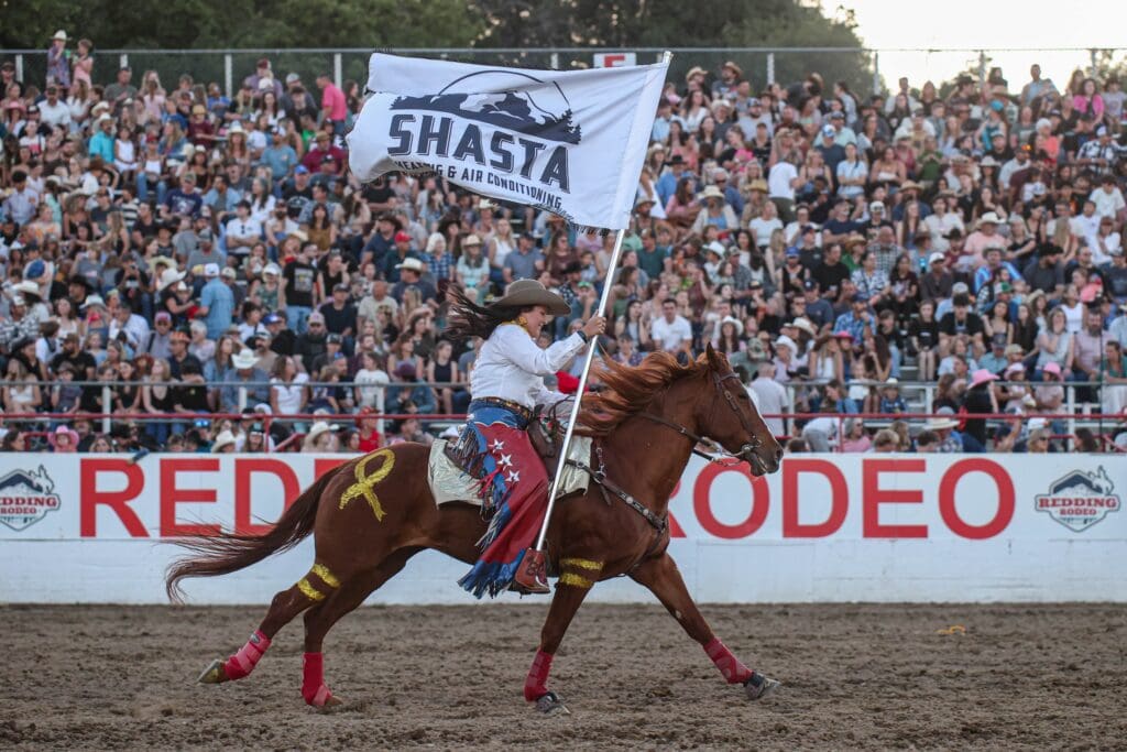 Rodeo queen carrying flag in the arena