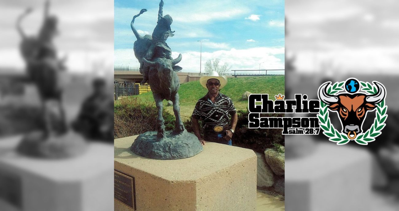 Charlie Sampson taking a picture next to his bronze in the PRCA Hall of Fame Garden in 2014