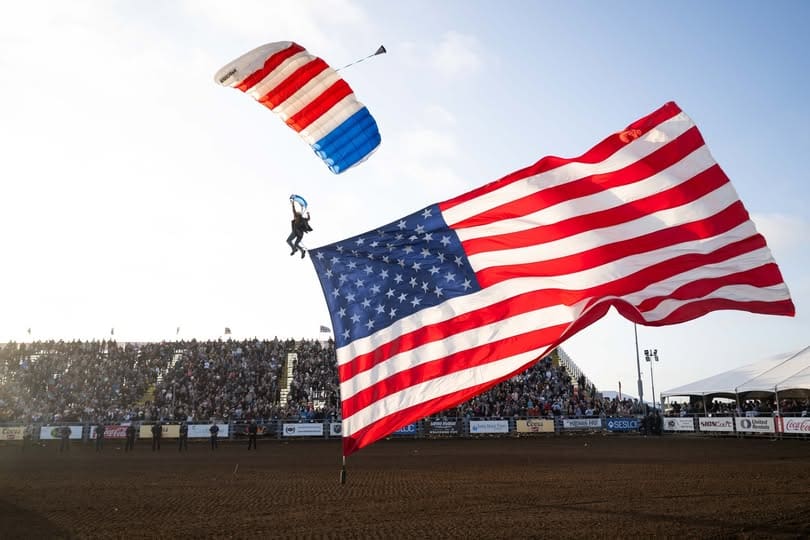 Paraglider carrying American Flag entering arena