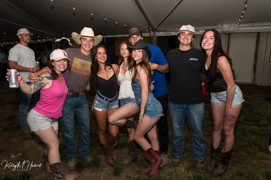 Group of friends smiling for a photo at rodeo after party.