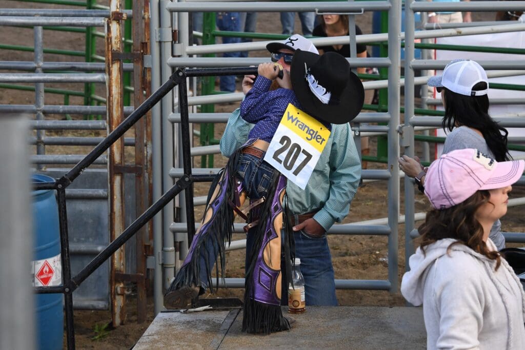 Kiddo with his cowboy gear on behind the bucking chute