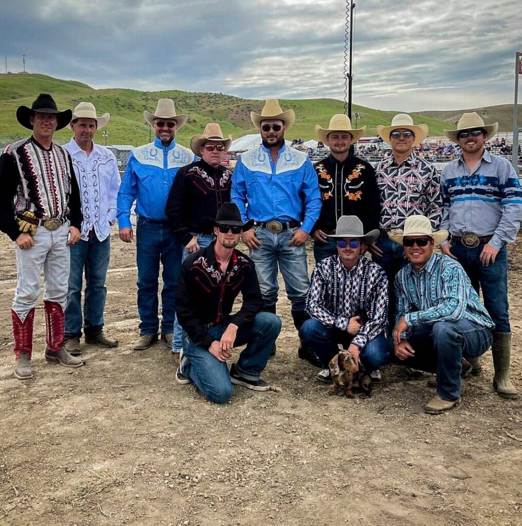 Group of cowboys smiling for a photo wearing their retro cowboy outfits for Retro Night.