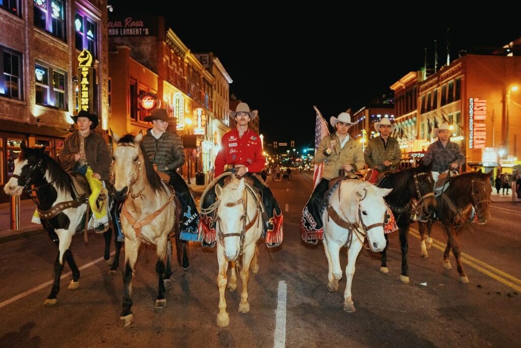Cowboys riding horses down Nashville street