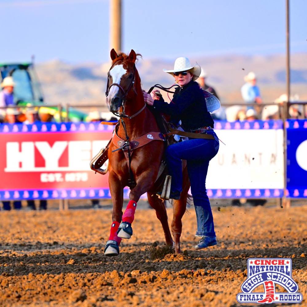 Female athlete jumping off horse at National High School Finals Rodeo