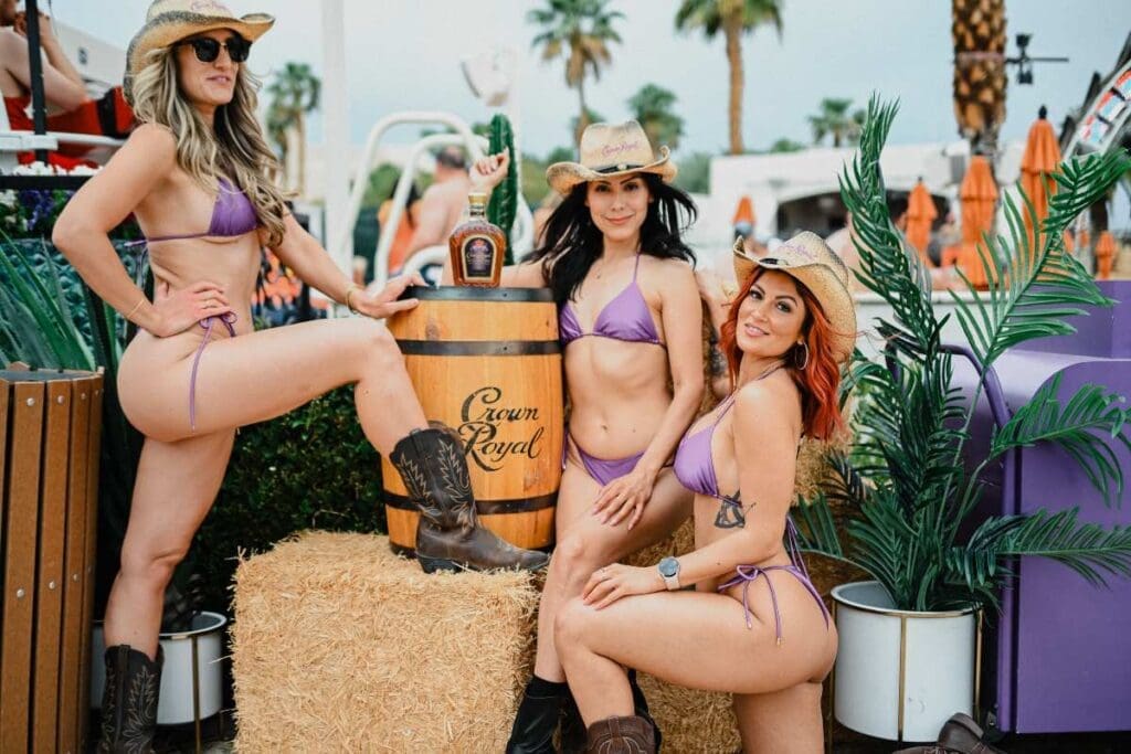 3 girls in crown royal bikinis with a crown royal bottle