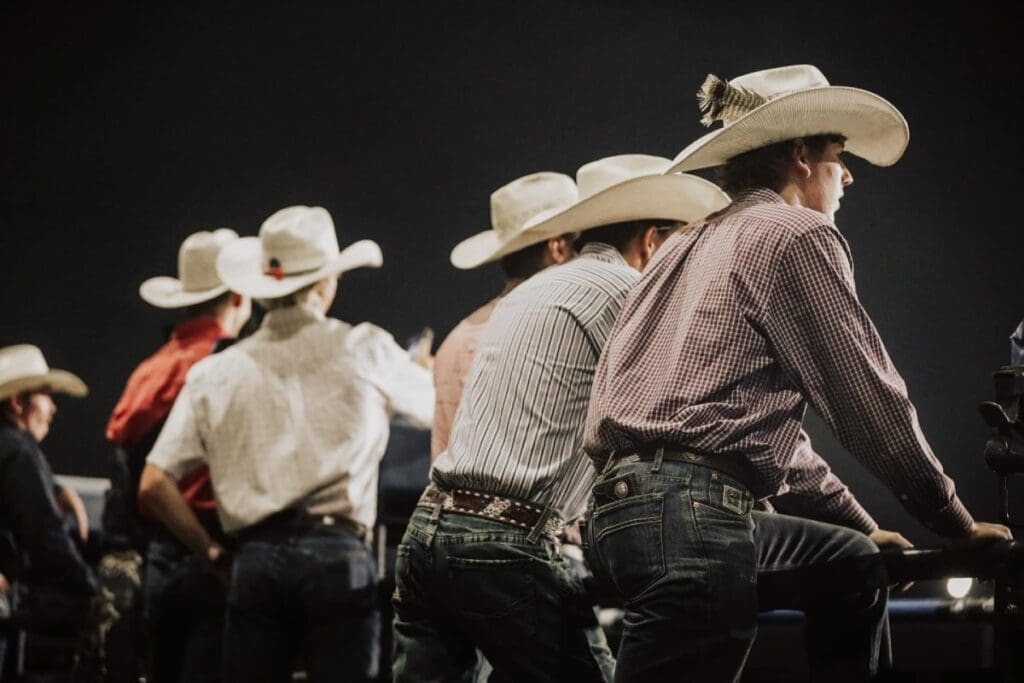 Side view of Cowboys Lined Up Watching Cody Nites