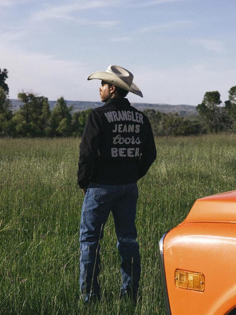 Man in a field staring into the distance wearing a Wrangler Coors Pinnacle Jacket