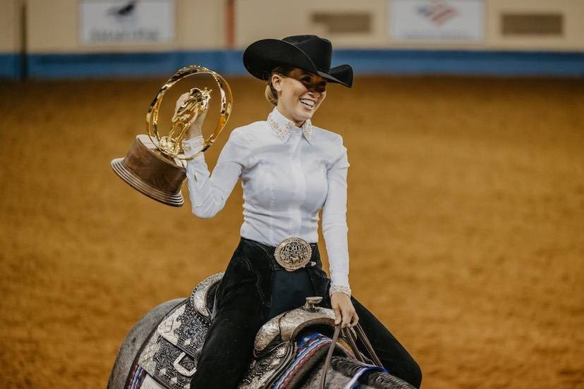 Female on Horseback holding her AQHA Trophy