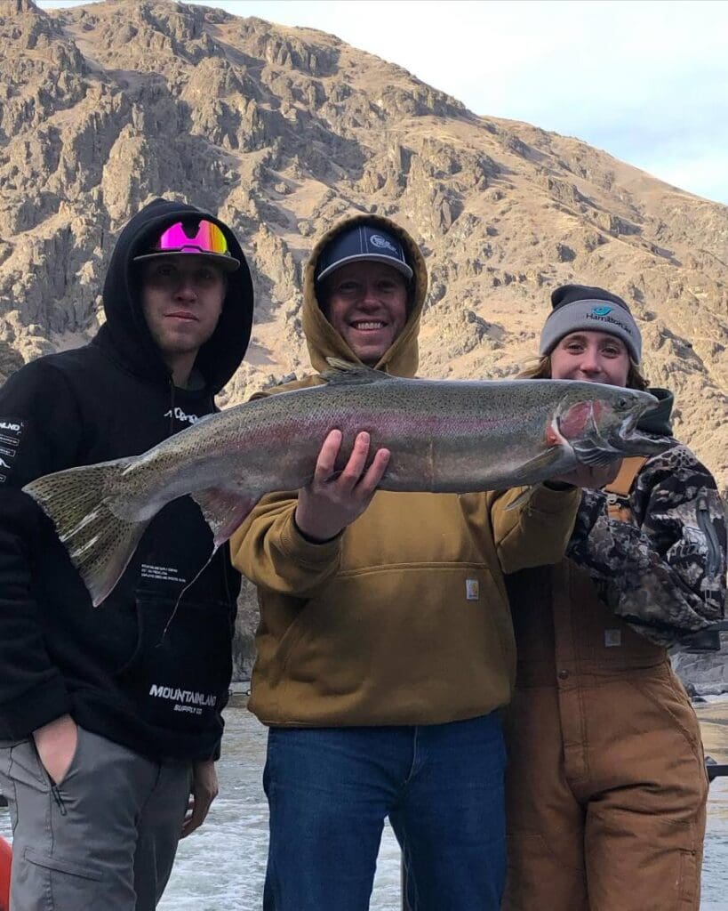 3 people holding up a large fish they caught on a Kilgore Adventure