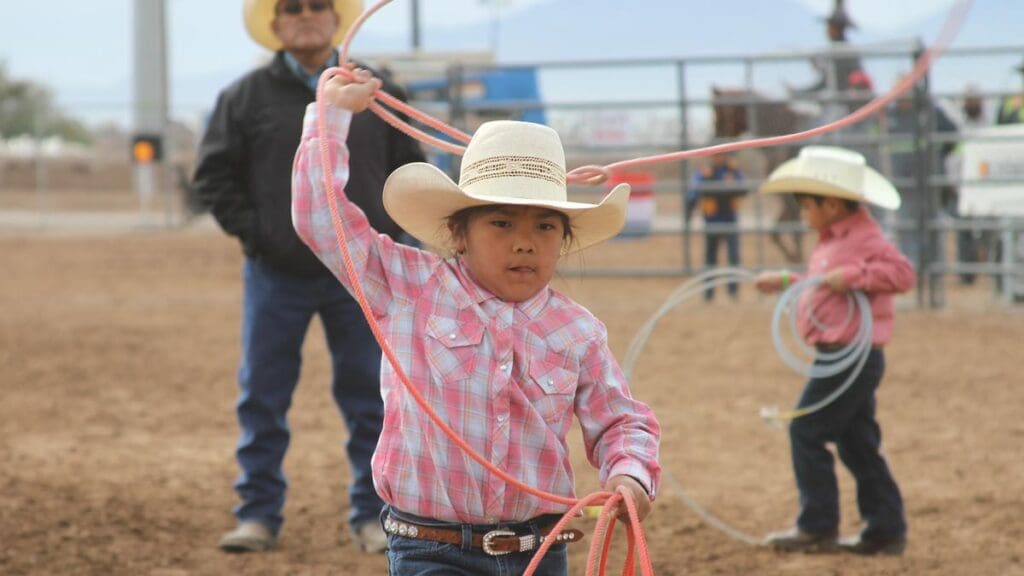 Young cowgirl roping