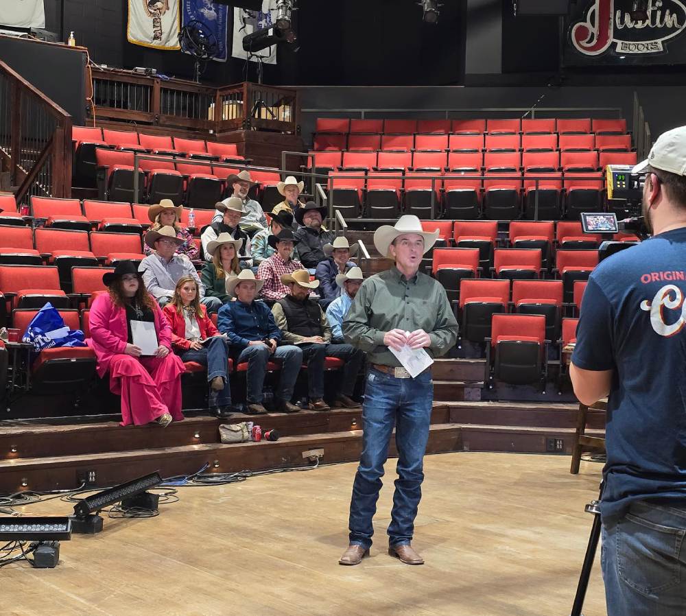 Justin McKee speaking to arena of students