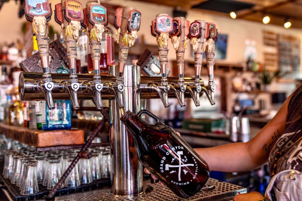 person filling a growler at a bar