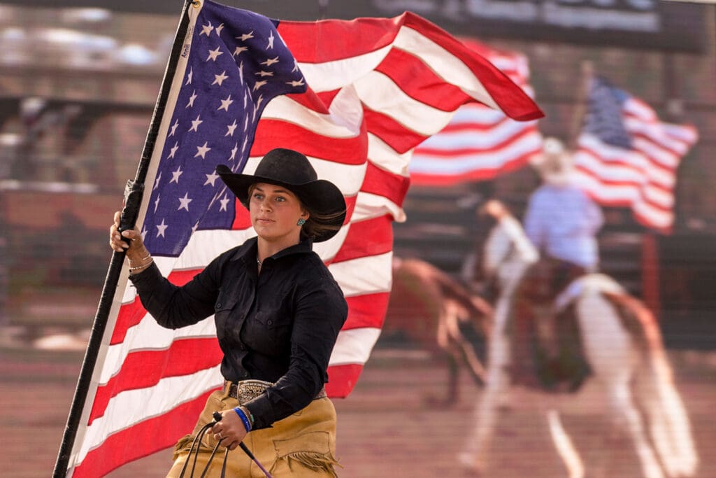 Cowgirl carrying American Flag at Art of the Cowgirl