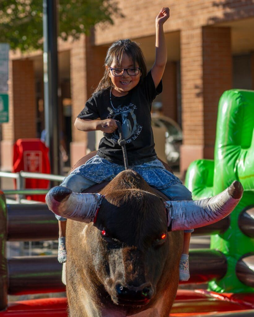 Child riding a mini mechanical bull at The Hondo Rodeo Fest