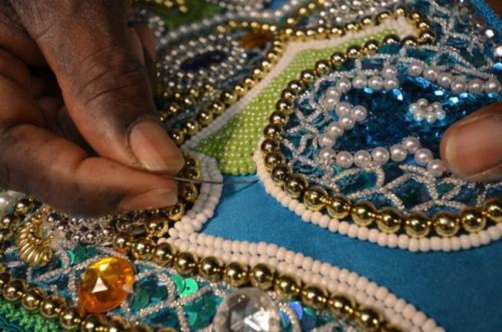 Sewing on all the fine bead details to a Mardi Gras costume