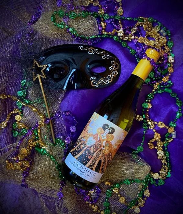 Mardi Gras beads and mask with a bottle of wine. Vibrant purple, green and gold colors.