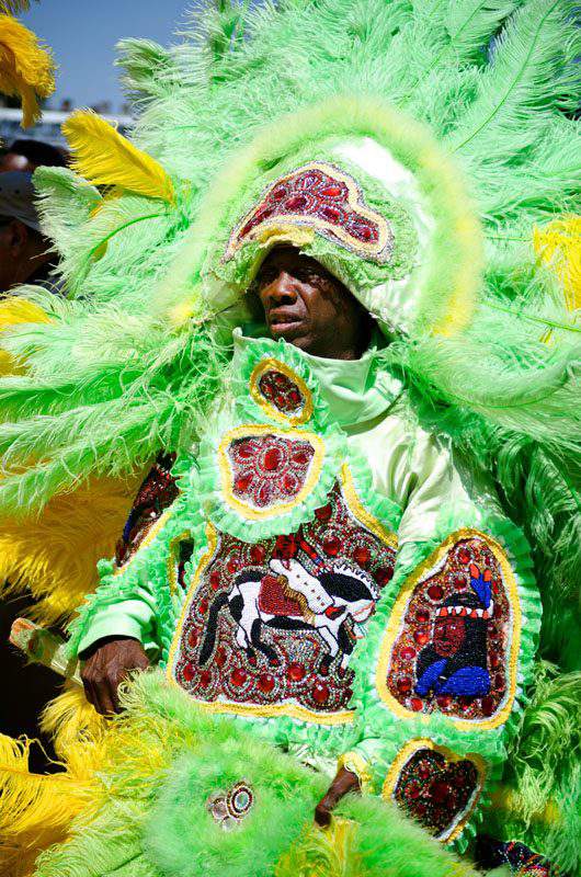 Elaborate Mardi Gras Costume made of lime green and yellow beads with a several Native American symbols. Photo credit: mardigrasneworleans.com