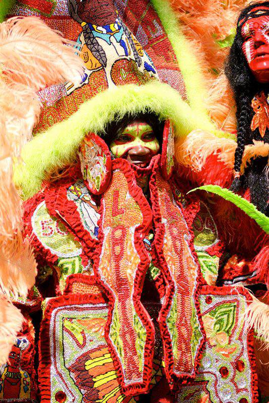 Elaborate Mardi Gras costume made with red, yellow, lime green and orange beads