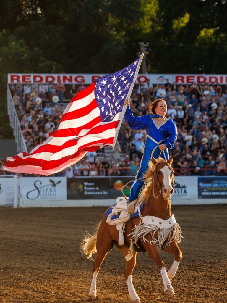 Performer carrying the American Flag at the Redding Rodeo