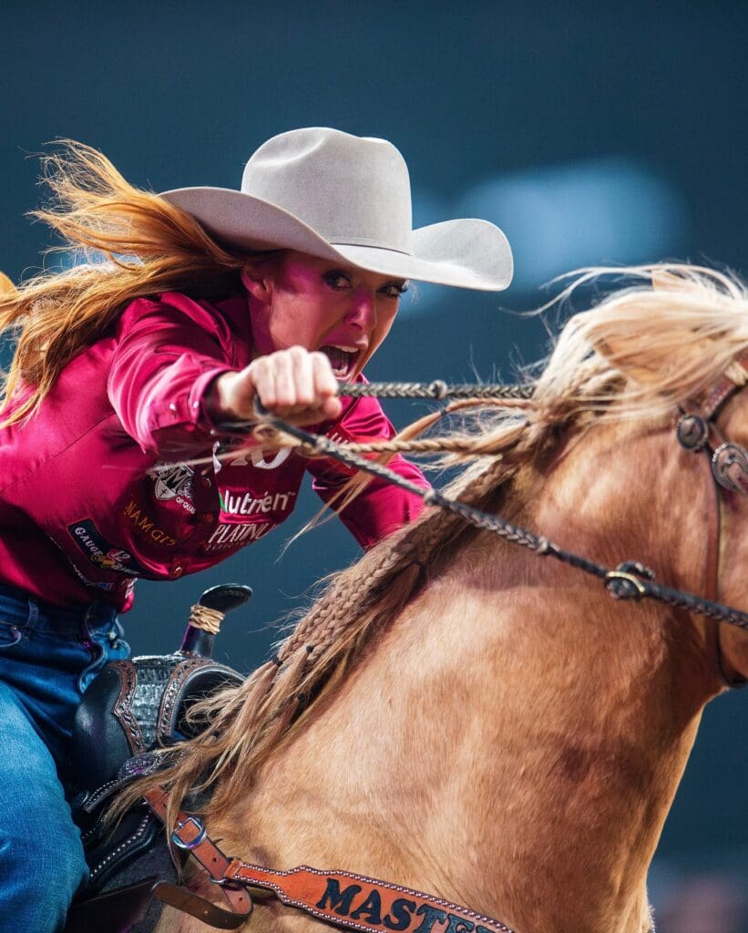 Cowgirl on horse looking at camera during barrel run