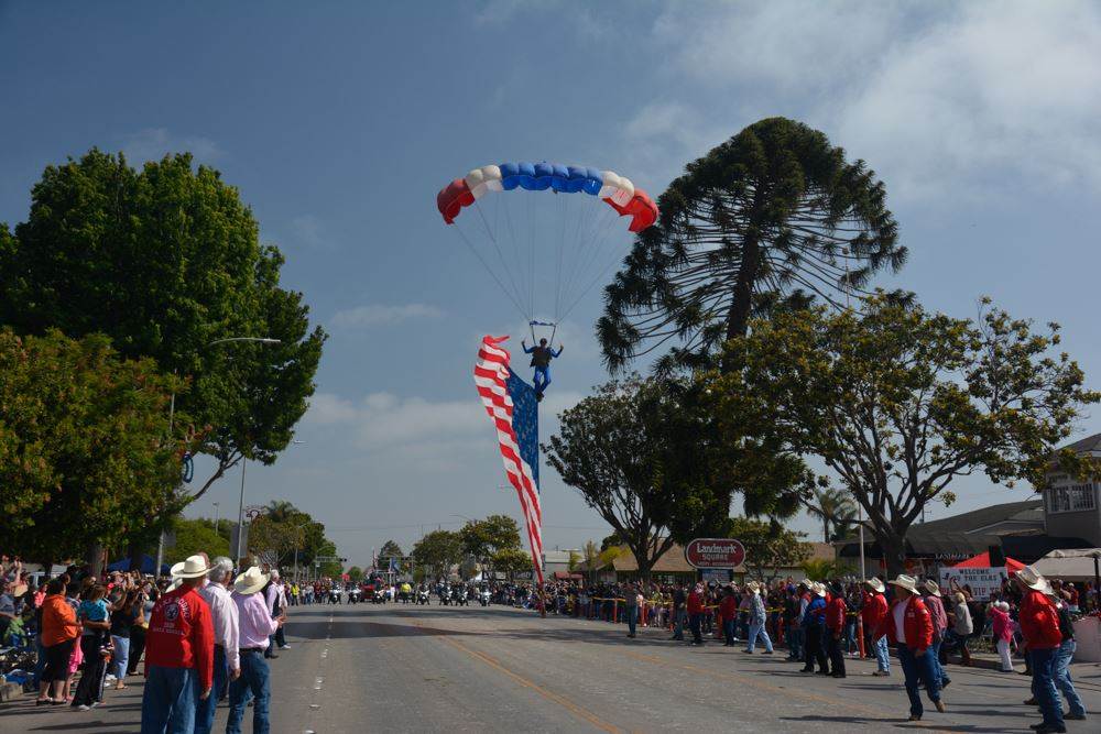 Sky diver landing during Elks Rodeo Parade