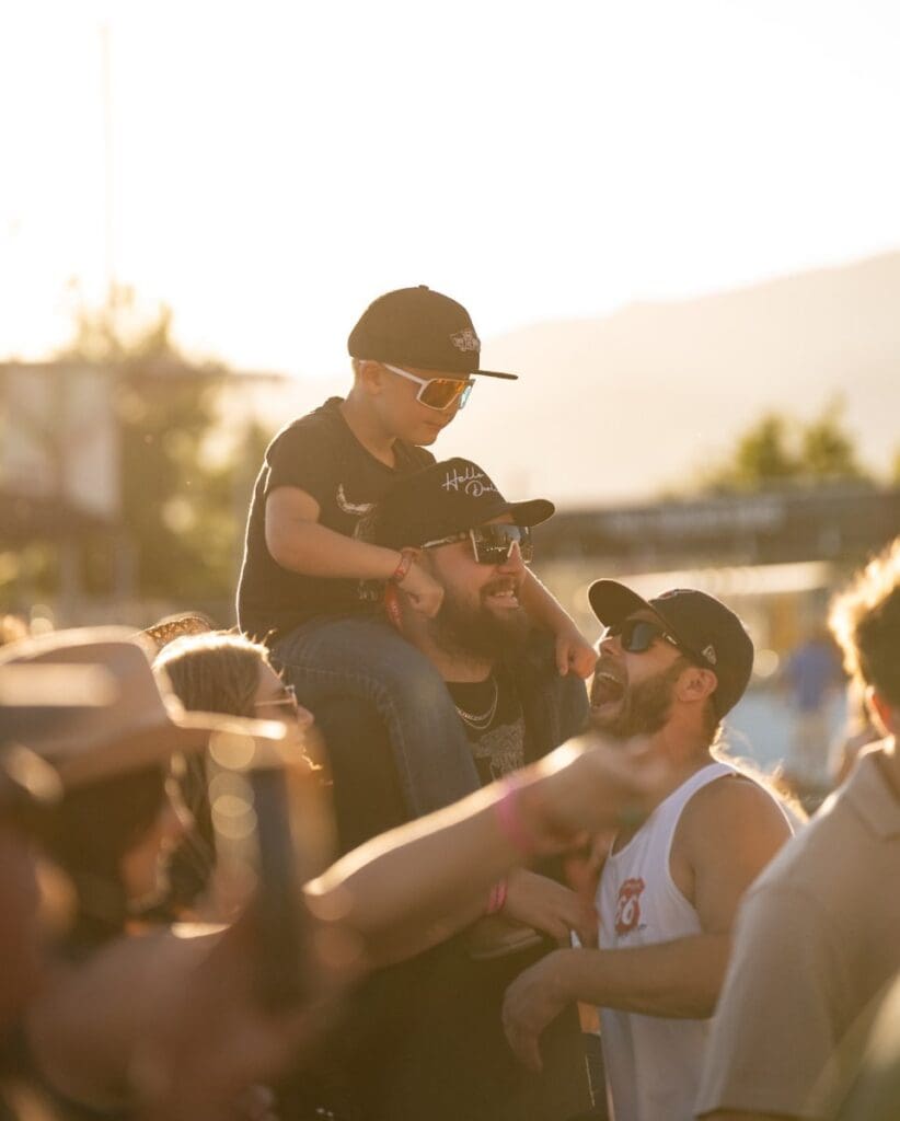 Young child on the shoulders of a man.  Photo credit:  Drifters Music Festival Facebook