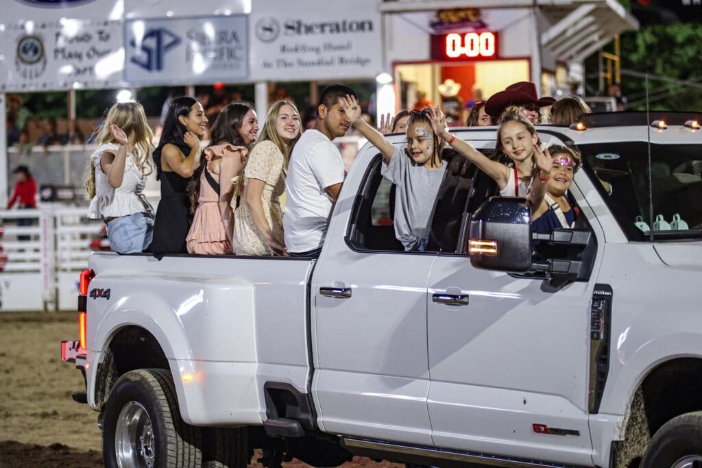 Redding Rodeo kids waving from the back of a truck
