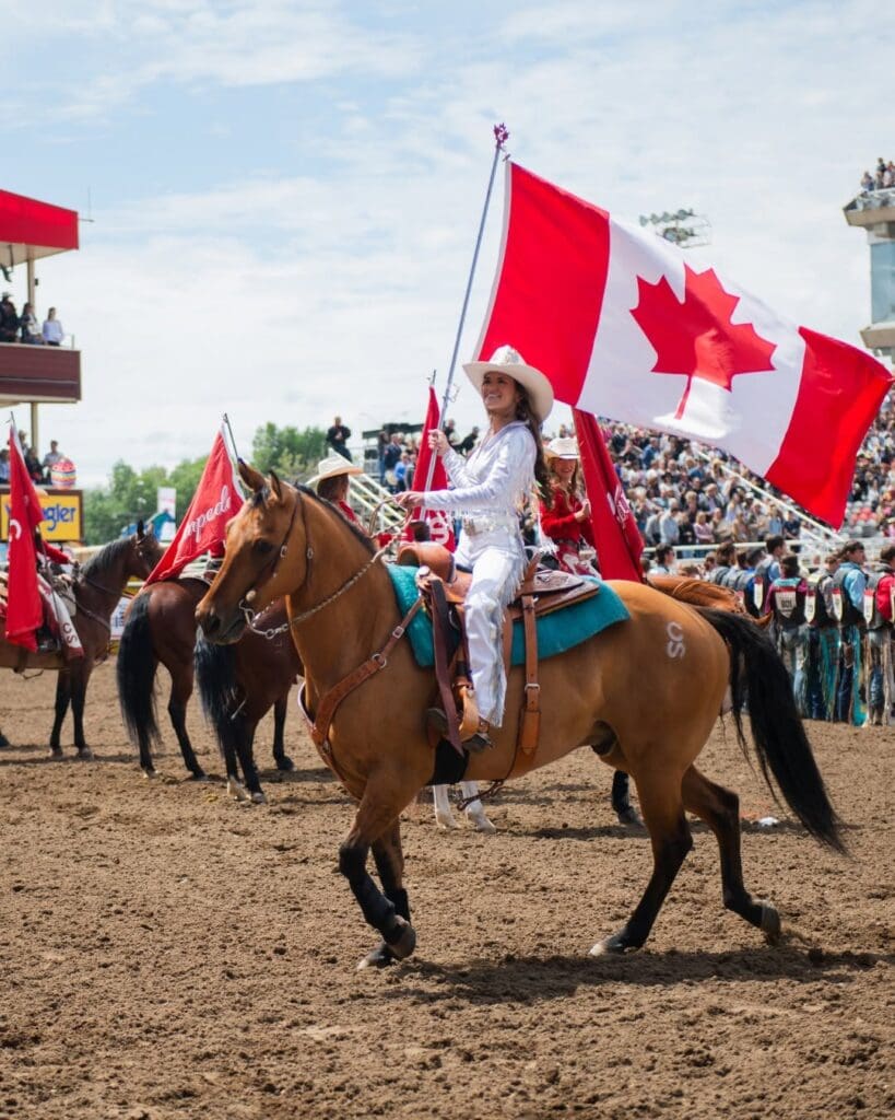 Cowgirl holding Canadian flag at the Calgary Stampede