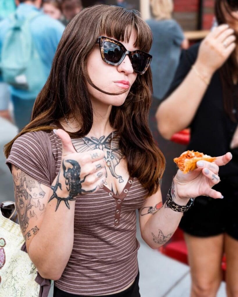 Fair patron giving a thumbs up as she tries fair food.