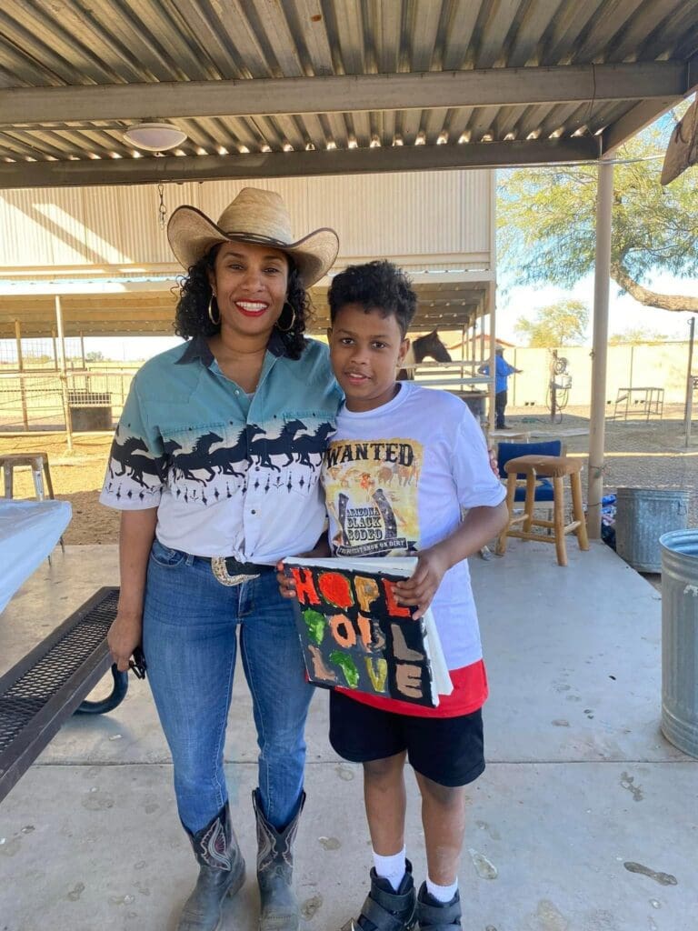 Cowgirl and kid smiling at the Arizona Black Rodeo